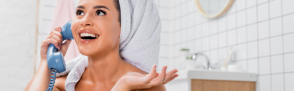 Kafasında havlu olan neşeli bir kadın banyoda telefonla konuşuyor bulanık arka planda, pankartta.  - Fotoğraf, Görsel