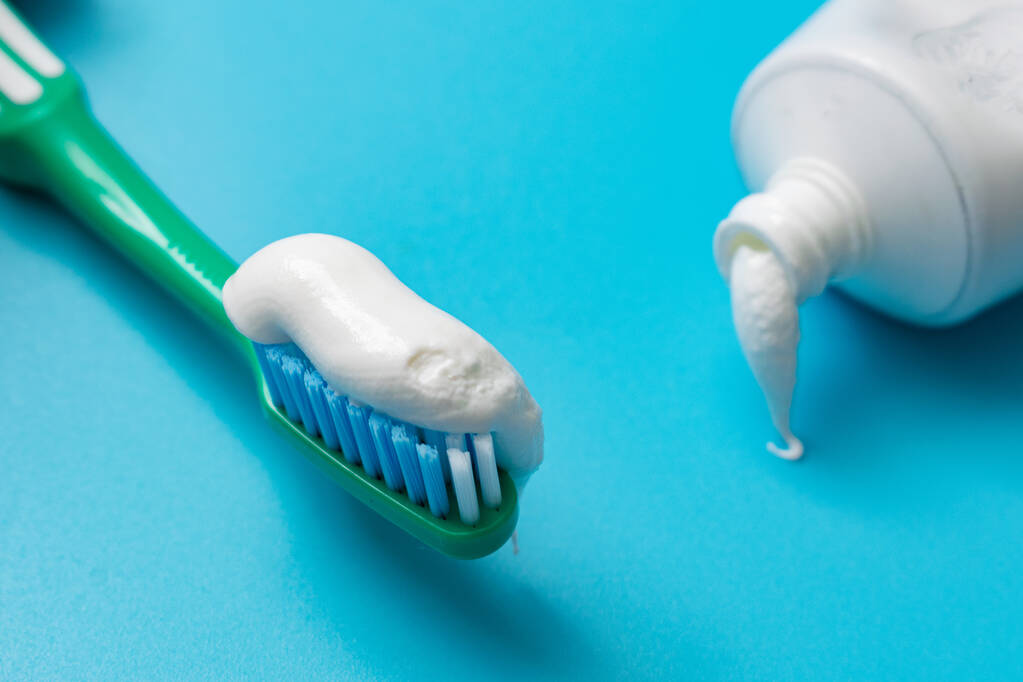 Brosse à dents et dentifrice sur fond bleu. Concept d'hygiène dentaire. - Photo, image
