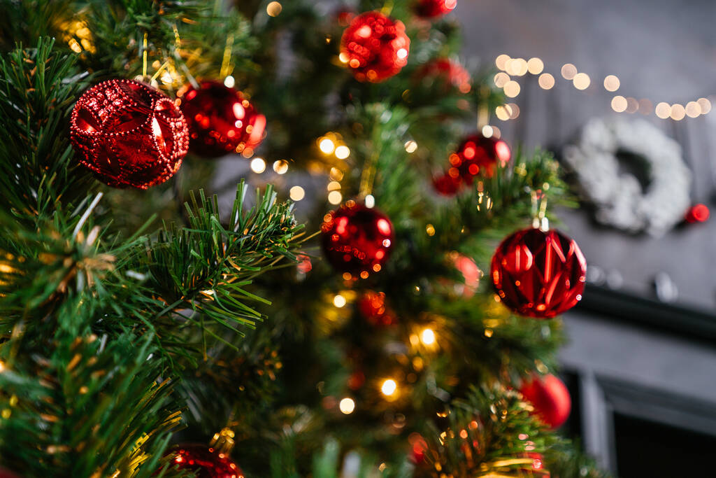Новый 2021 год интерьер со свечами, луковицами и боке. Комнату украсили к празднованию Рождества. Рождественская елка с подарками - Фото, изображение