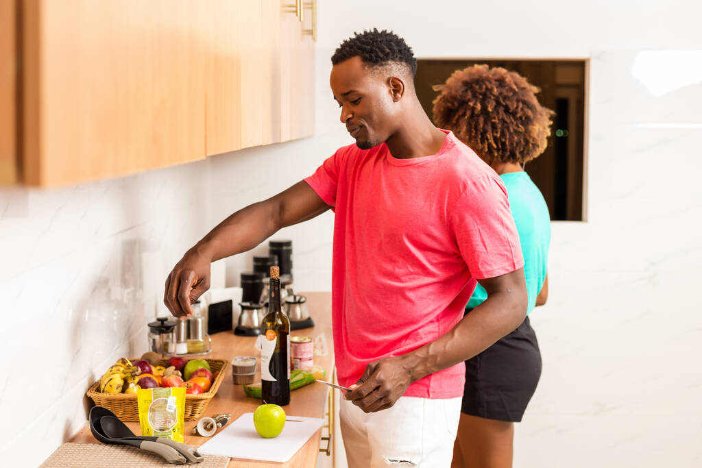 Афроамериканська пара готує їжу на кухні. - Фото, зображення