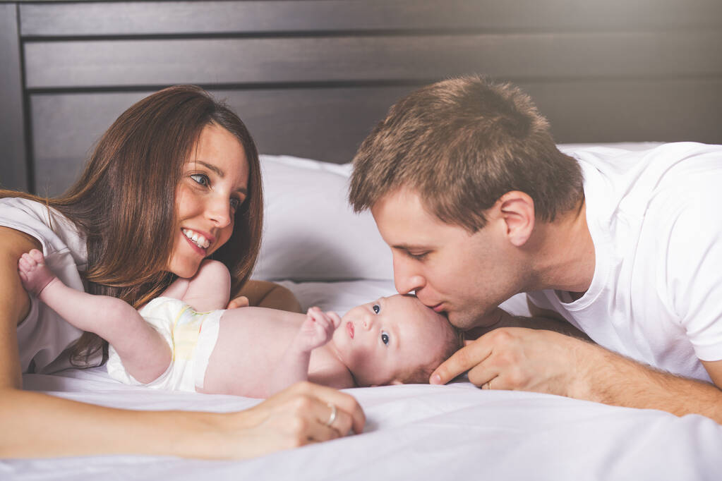 Mãe pai e bebê criança em uma cama branca. - Foto, Imagem