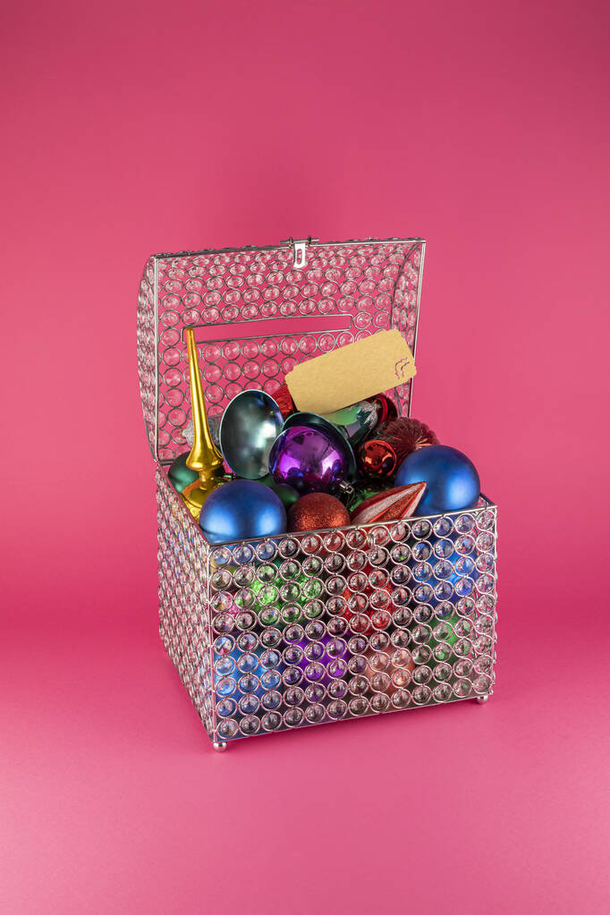 Een verticaal shot van een doos vol kleurrijke kerstboom speelgoed - Foto, afbeelding