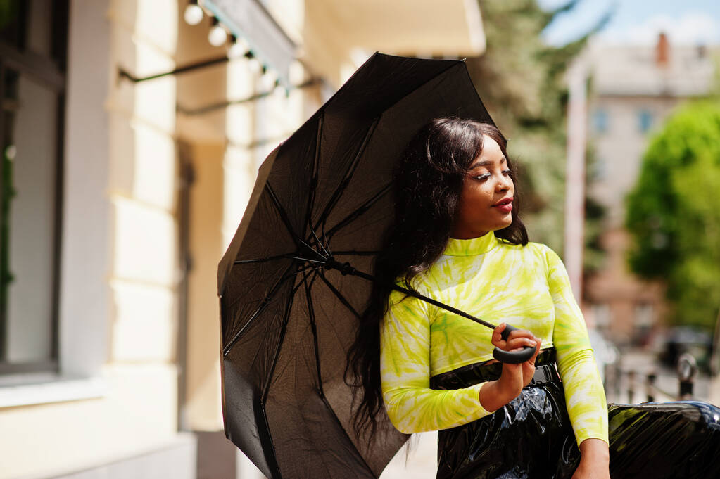 Ritratto di giovane bella donna afroamericana con ombrello nero in mano. - Foto, immagini