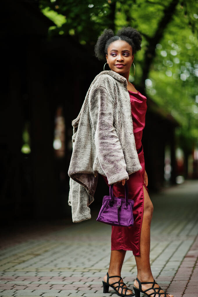 Portret van een prachtige natuurlijke jonge Afrikaanse vrouw met afrohaar. Zwart model in rode zijden jurk. - Foto, afbeelding