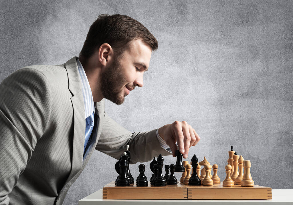Concentrated businessman playing chess game - Photo, Image