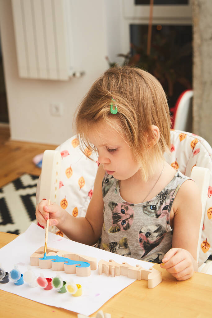 Gyerekfestés. Boldog óvodás lány kezében ecsettel festett festék. Csináld magad, a gyerekekkel otthon. Sekély dof - Fotó, kép