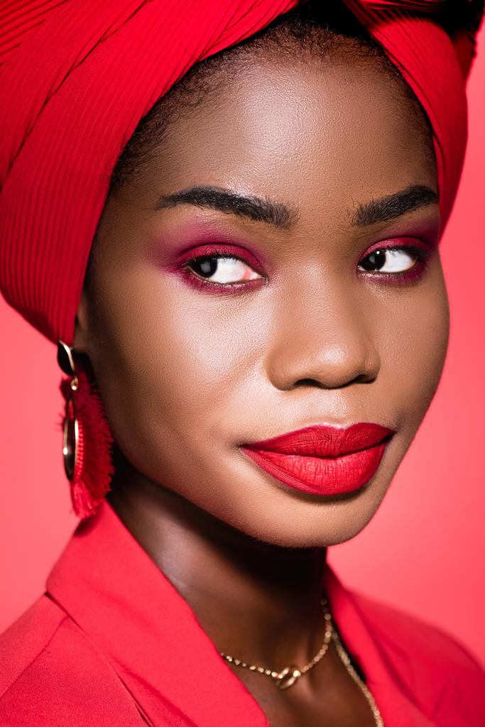 Afrykańska młoda kobieta w stylowym stroju i turban izolowane na czerwono - Zdjęcie, obraz