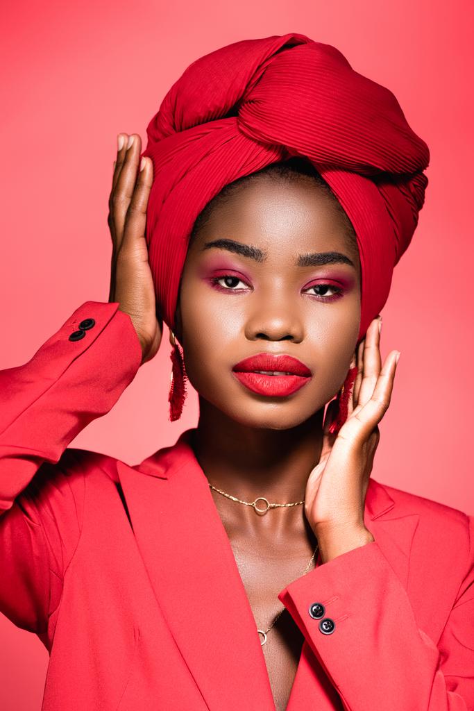 african american young woman in stylish outfit and turban isolated on red - Photo, Image