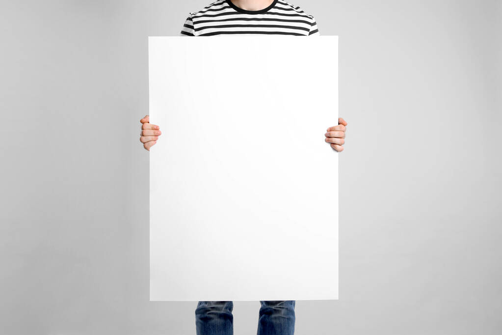 man houden blanco poster op licht grijze achtergrond, close-up - Foto, afbeelding