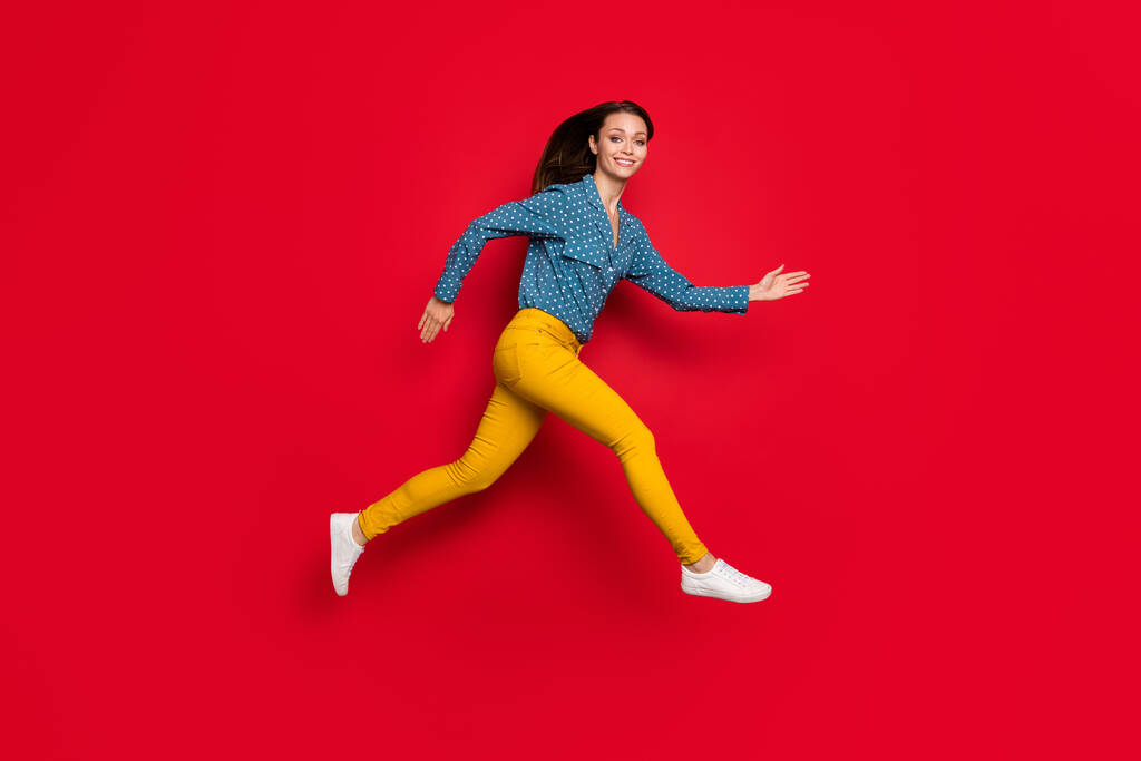 Pełna długość ciała rozmiar profil boczny widok dość wesoły cienki motywowany dziewczyna skoki działa odizolowany na jaskrawo czerwony kolor tła - Zdjęcie, obraz