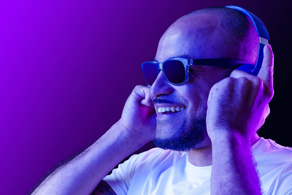Портрет афро-американца, слушающего музыку в неоновом свете - Фото, изображение