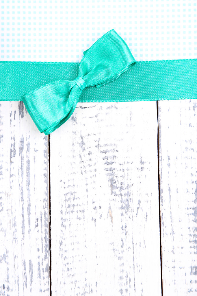 Барвиста тканина з кольоровою стрічкою та бантом на дерев'яному фоні
 - Фото, зображення