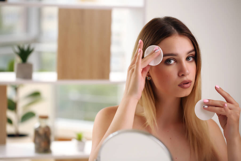Young beautiful woman applying make up using small mirror - Photo, Image