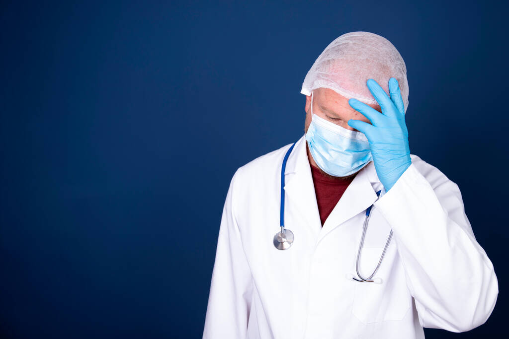 Αγχωμένος, κουρασμένος γιατρός κατά τη διάρκεια της COVID-19 που χρειάζεται βοήθεια στο νοσοκομείο. Οι εργαζόμενοι στον τομέα της υγείας είναι απελπισμένοι. Στεφανιαίος πυρετός θάνατος κρίση, απελπισία, ψυχική υγεία άγχος. - Φωτογραφία, εικόνα