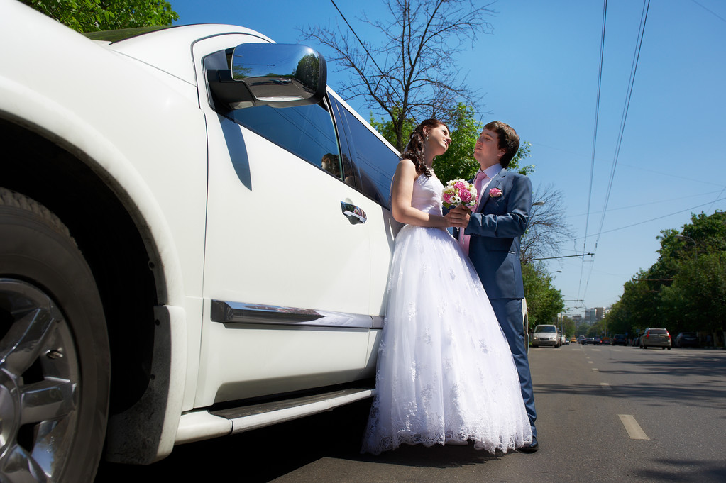 Braut und Bräutigam über Hochzeitslimousine - Foto, Bild