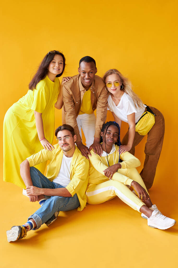 Ομάδα πολυεθνικών φίλων, άνθρωποι διαφορετικών πολιτισμών απομονωμένοι σε κίτρινο φόντο - Φωτογραφία, εικόνα