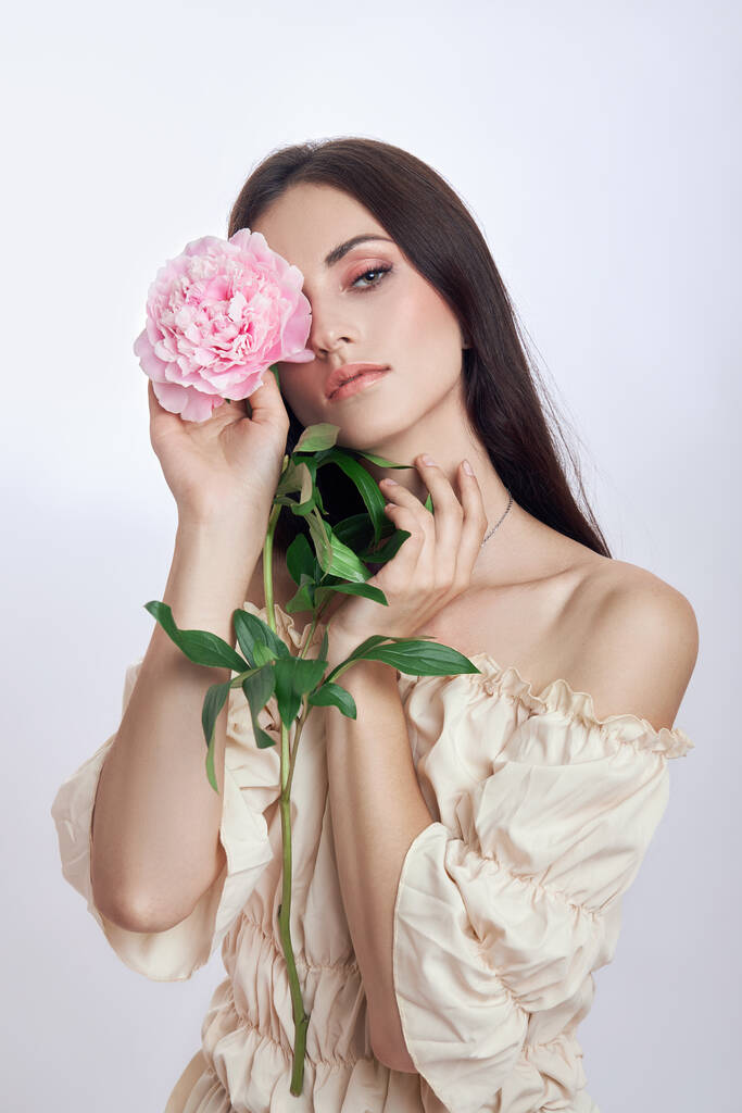 Belle femme avec beaucoup de fleurs roses dans ses mains. Femme sexy aux cheveux longs - Photo, image