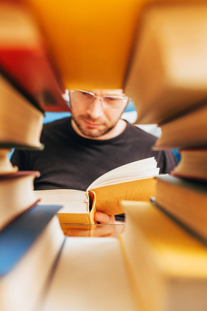 Polimatematyk czyta książki w bibliotece - zanurza się w nauce - Zdjęcie, obraz