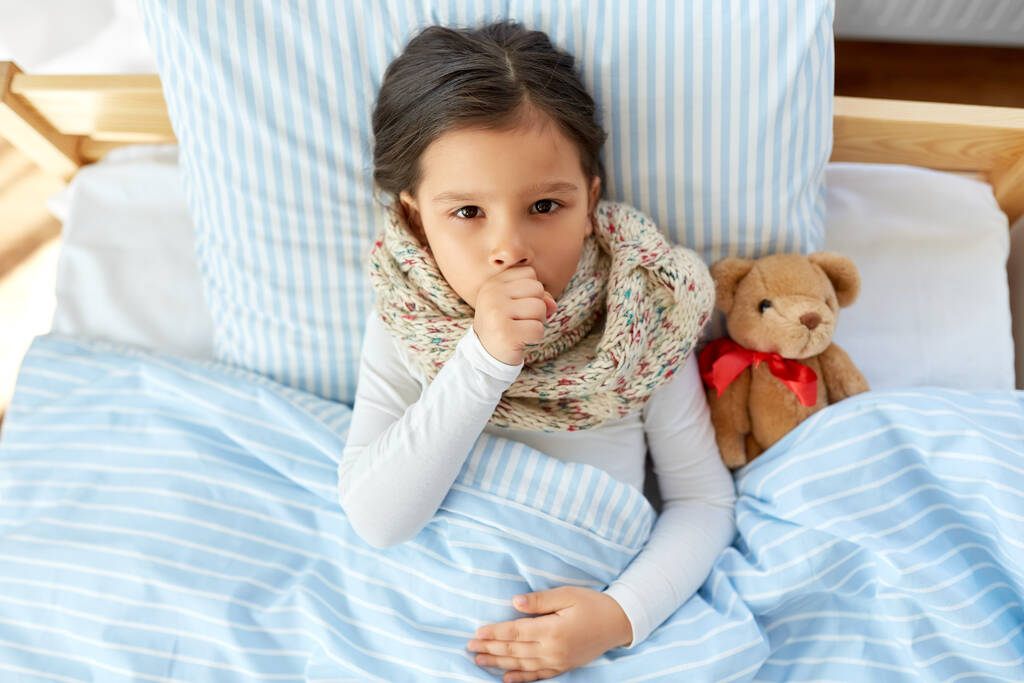 άρρωστη κοπέλα που βήχει ξαπλωμένη στο κρεβάτι στο σπίτι - Φωτογραφία, εικόνα