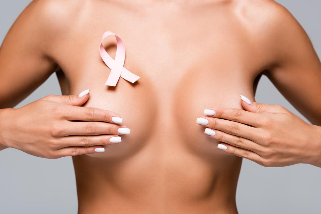 Обрезанный вид обнаженной женщины с раковой лентой груди трогательный бюст, изолированный на серой  - Фото, изображение
