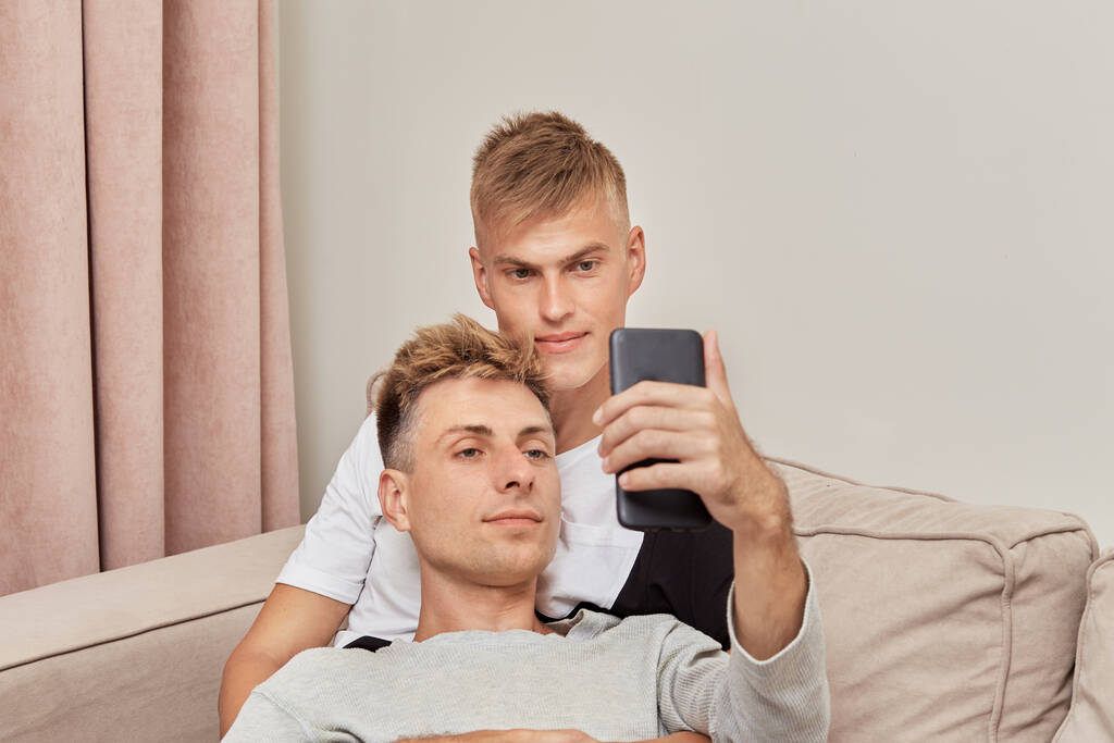 bello gli uomini gay coppia blogger prendendo selfies su loro smartphone. - Foto, immagini