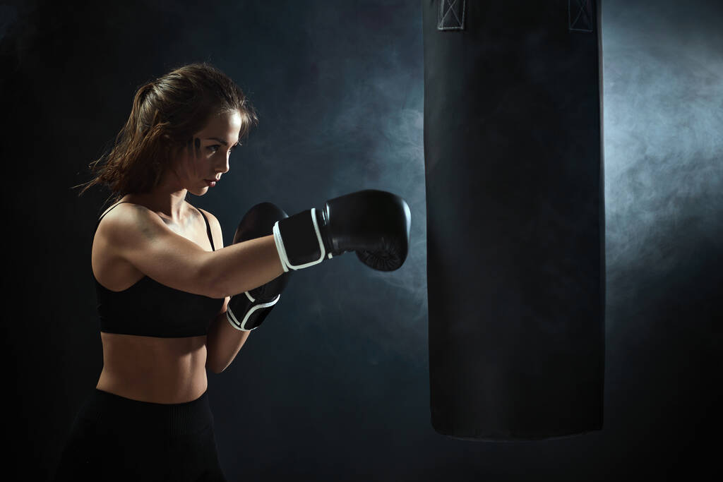 спортивна брюнетка жінка в боксерських рукавичках гладить
 - Фото, зображення