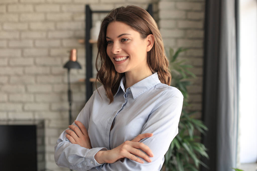 Atractiva mujer de negocios sonriendo mientras está de pie en la oficina - Foto, imagen