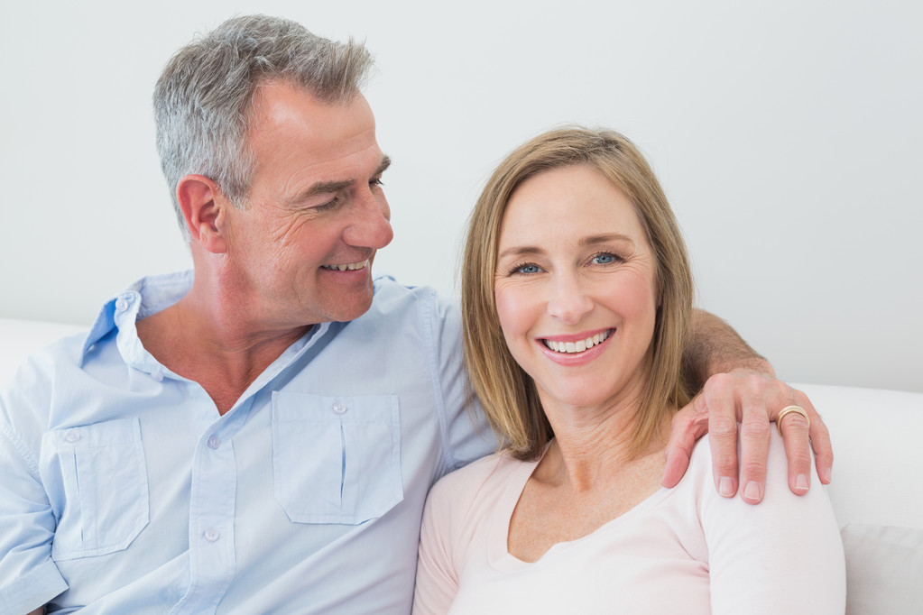 Relaxed couple sitting on sofa with arm around - Photo, Image