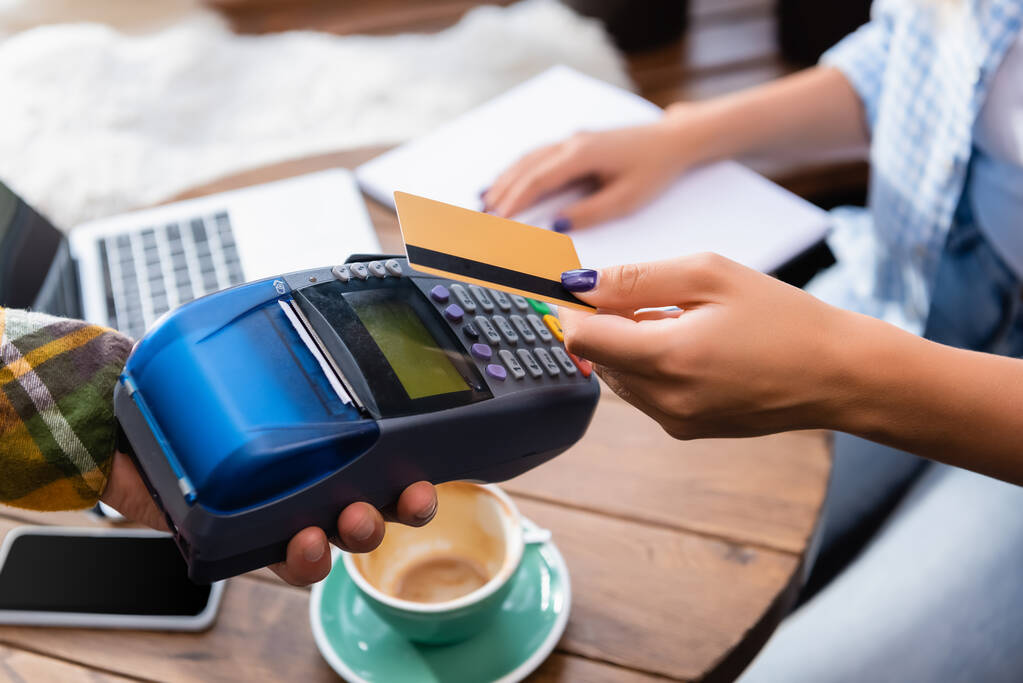vue recadrée de la femme tenant carte de crédit près du serveur avec terminal de paiement - Photo, image