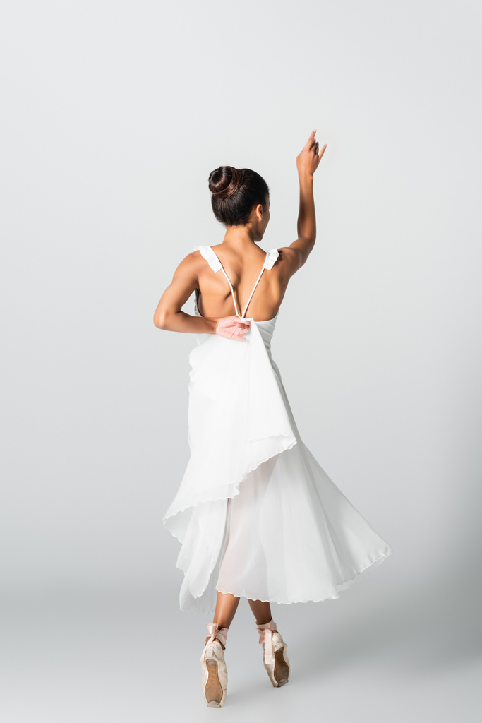 vista posteriore della graziosa ballerina afroamericana in abito da ballo su sfondo bianco - Foto, immagini