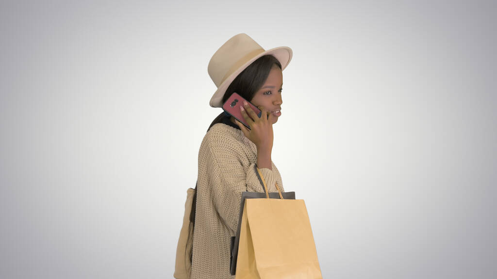 afroamericano ragazza in oversize maglieria e cappello parlando su h - Foto, immagini