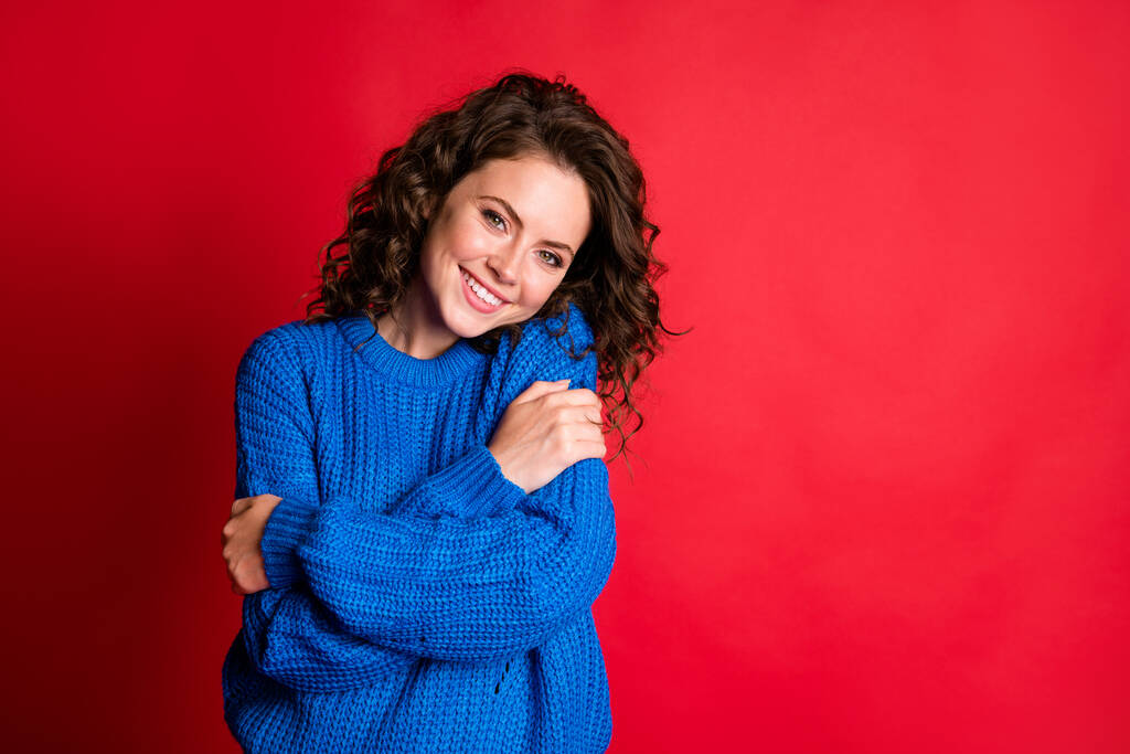 Portrait of her she nice attractive pretty lovely sweet cute cheerful cheery girl wearing casual cosy garment cloth hugging herself isolated bright vivid shine vibrant red color background - Photo, Image