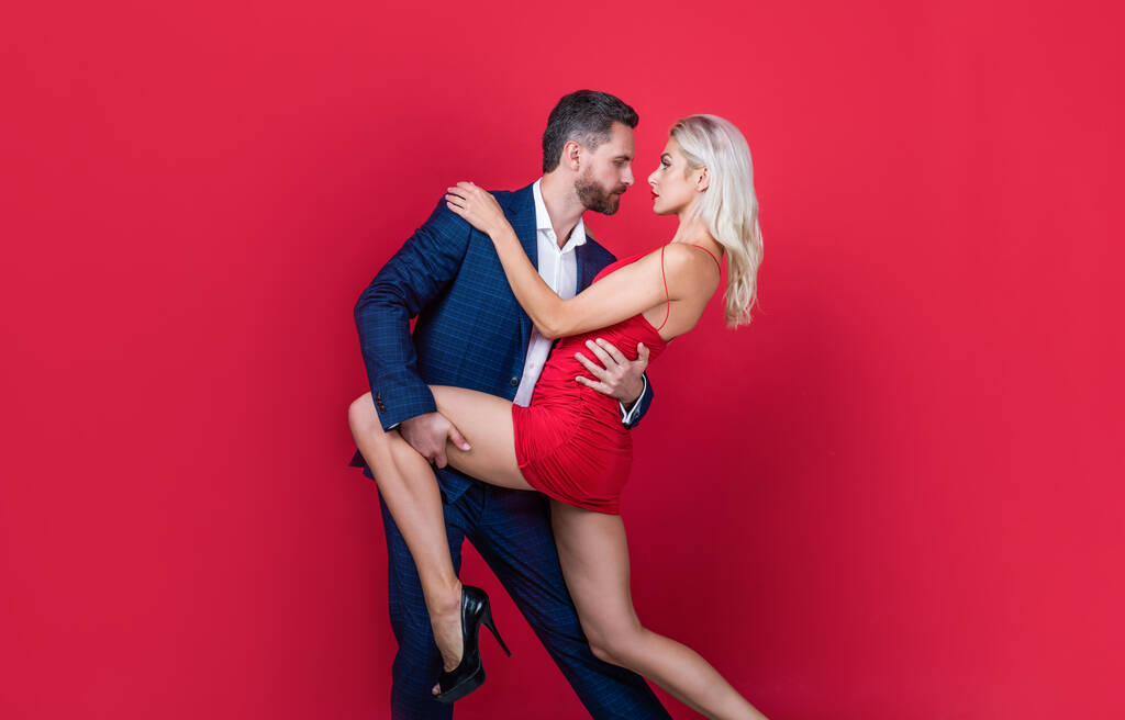 сексуальна формальна пара в любові обіймається на червоному тлі, відносини
 - Фото, зображення