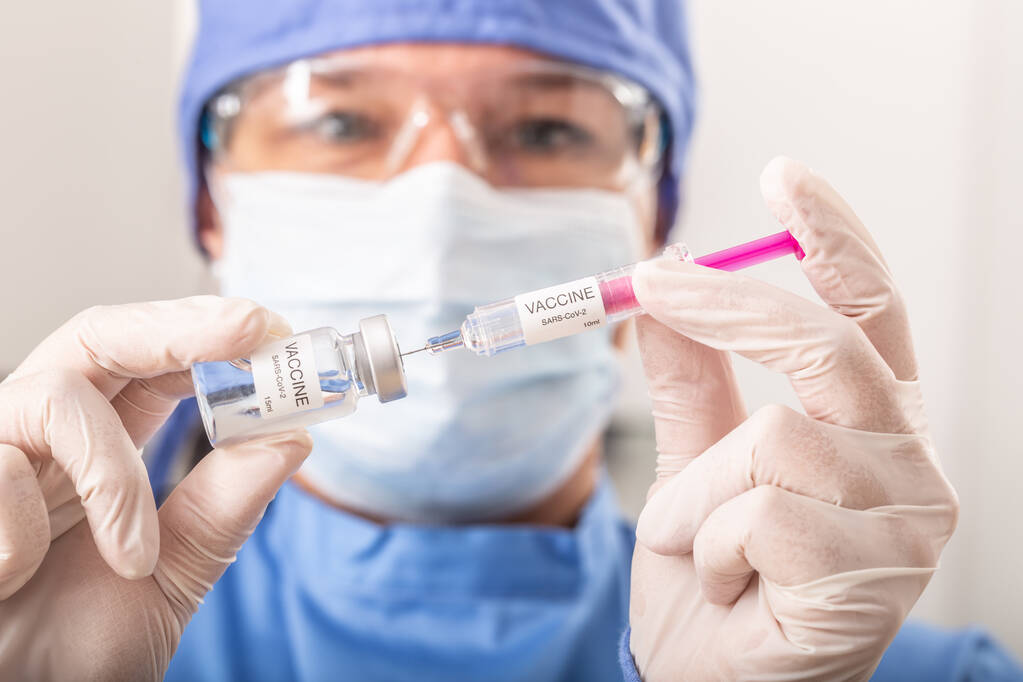 Ένας ιατρός που έβαλε το εμβόλιο SARS-CoV-2 ενάντια στον κορωναϊό σε μια ένεση.. - Φωτογραφία, εικόνα