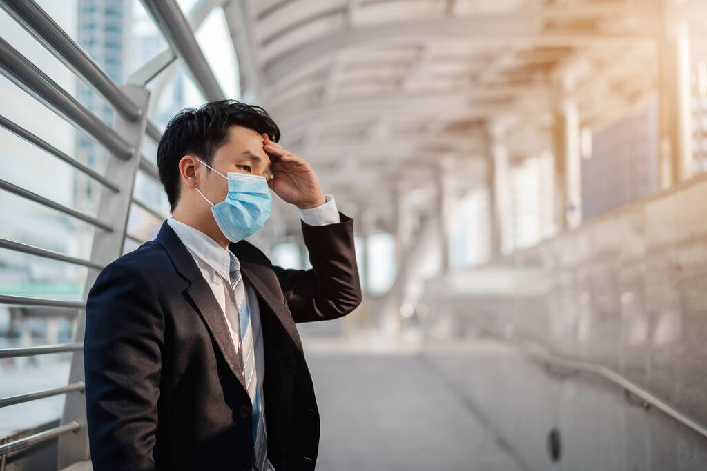 наголошений бізнесмен з медичною маскою під час пандемії коронавірусу в місті
 - Фото, зображення