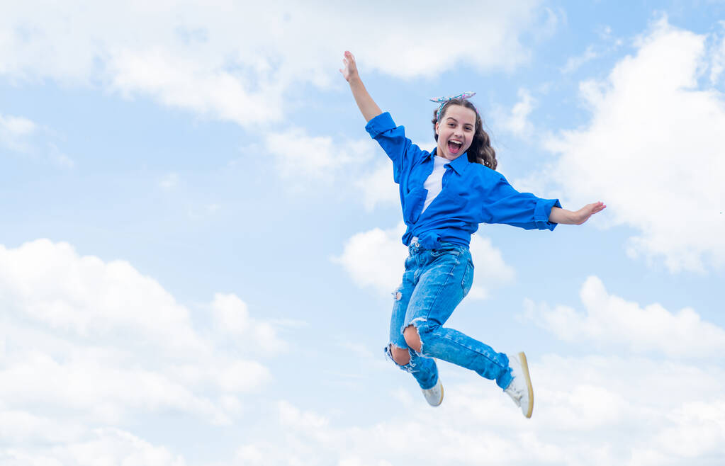 cheerful teen girl jumping high. kid jump outdoor. kid fashion and beauty. sense of freedom. portrait of energetic child girl. concept of future. happy childhood. Feeling free and happy - Photo, Image