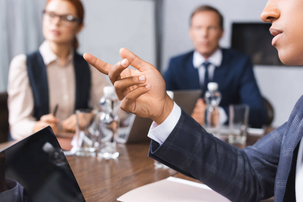 Close up view of african american businessman pointing with finger with blurred colleagues on background in boardroom - Photo, Image