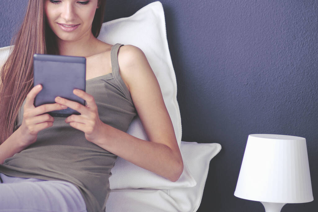 Nő ül a padlón egy digitális tabletta segítségével - Fotó, kép