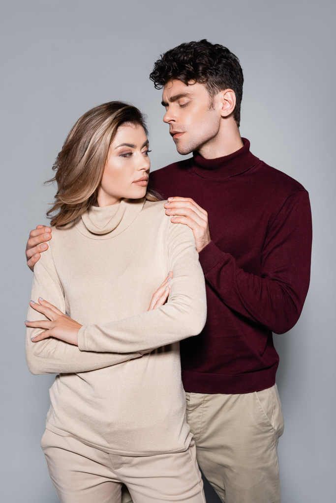 lässiges junges Paar in Pullovern posiert isoliert auf grau - Foto, Bild