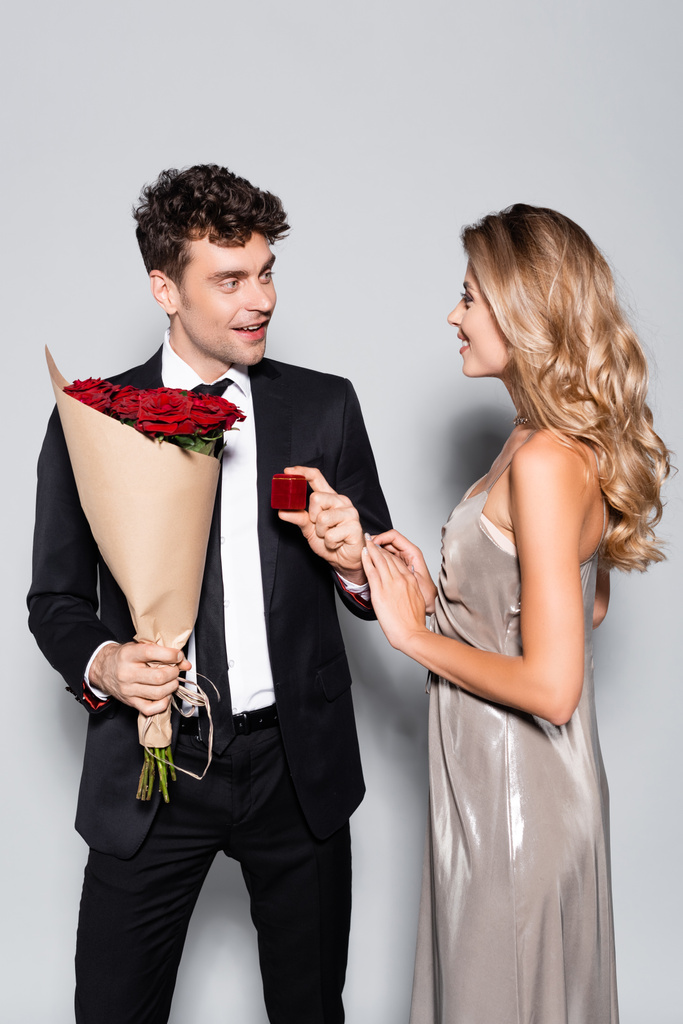 elegantní mladý muž s kyticí dělá sňatek návrh izolované na šedé - Fotografie, Obrázek
