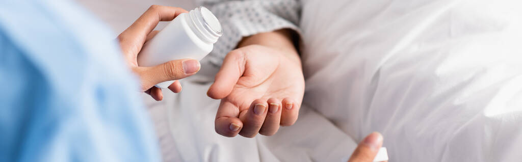 vista cortada de enfermeira segurando recipiente de medicamentos perto do paciente idoso, banner - Foto, Imagem