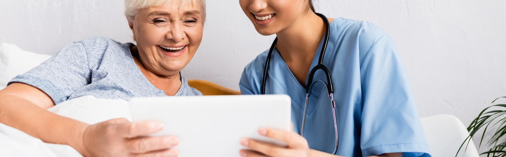 enfermera alegre y feliz anciana utilizando tableta digital juntos, bandera - Foto, Imagen