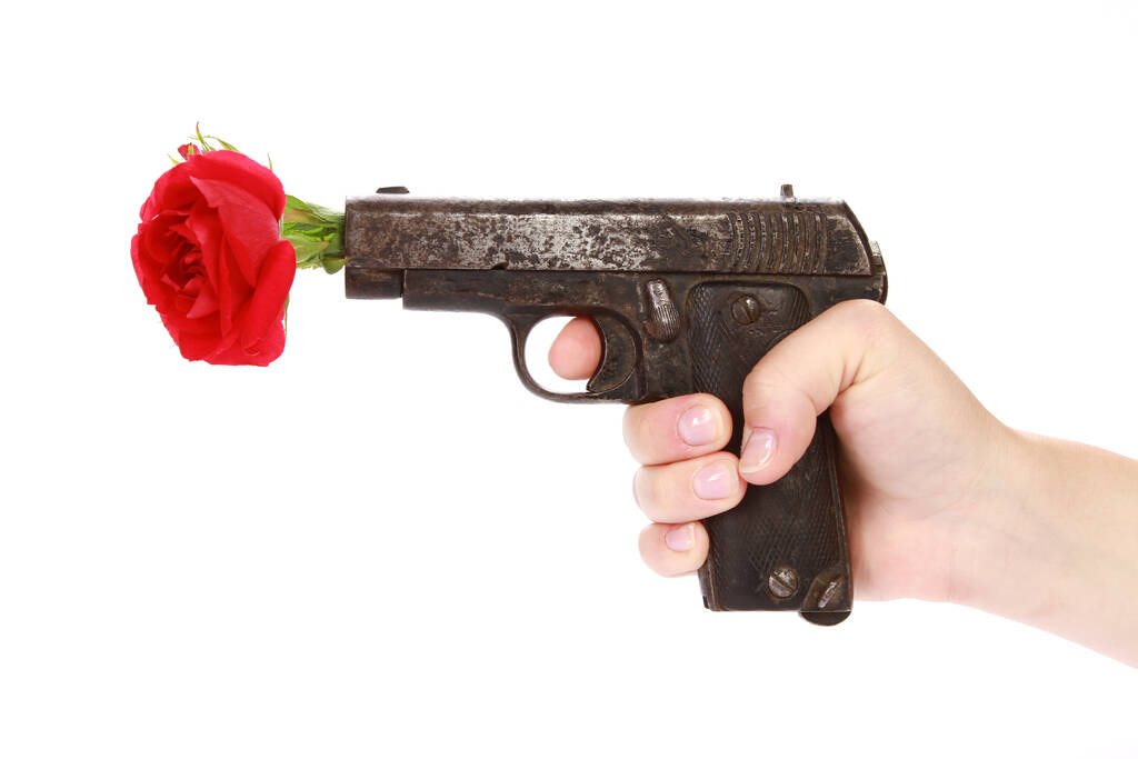 A red rose on a gun isolated on a white background - Photo, Image