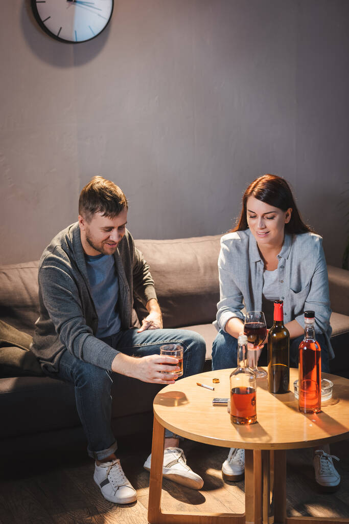 залежний від алкоголю чоловік і дружина п'ють алкоголь вдома разом
 - Фото, зображення