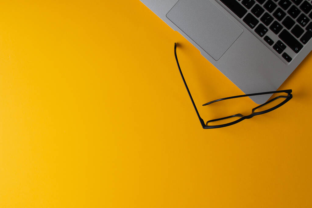 Horní pohled na laptop na žlutém stole - Fotografie, Obrázek