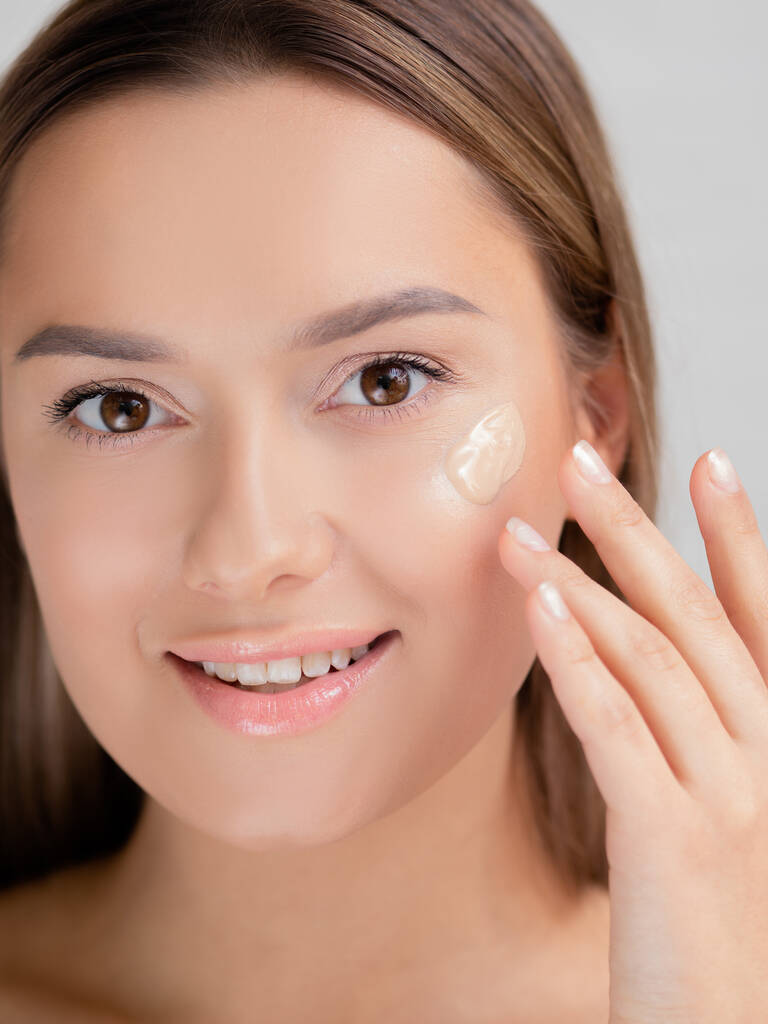 Face care e maquiagem, uma jovem mulher se aplica Fundação para a pele. - Foto, Imagem