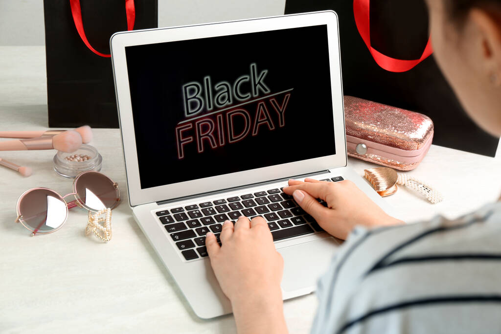 Woman using laptop with Black Friday announcement at white table, closeup - 写真・画像