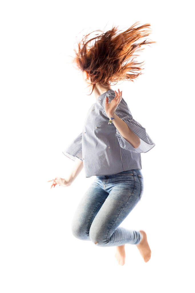 Teenage long hair girl jumping on white background. - Photo, Image