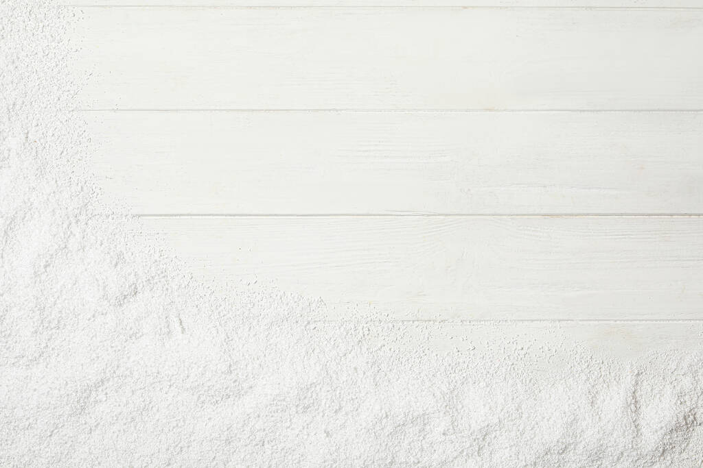 Nieve artificial sobre fondo de madera blanca, vista superior con espacio para texto. Decoración de Navidad - Foto, imagen