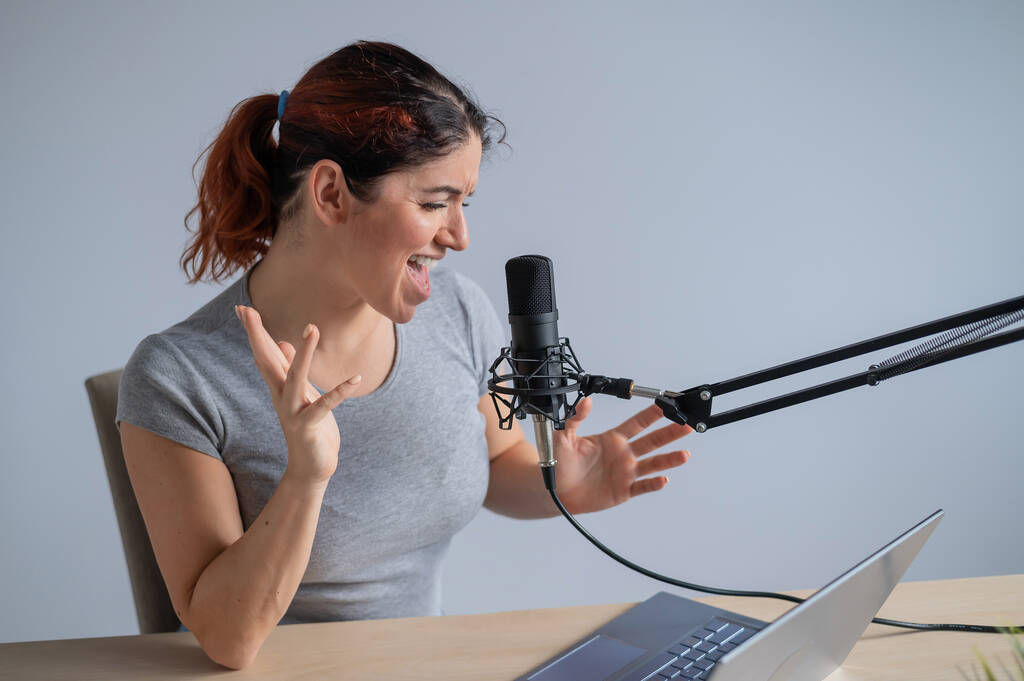 Viehättävä naisradiojuontaja lähettää suorana kannettavalla. Online radio käsite - Valokuva, kuva